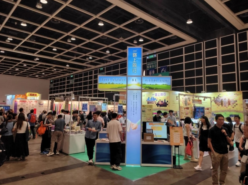 The striking illuminated cross at the Chinese Bible International booth stands out as a prominent landmark in the Christian Square.